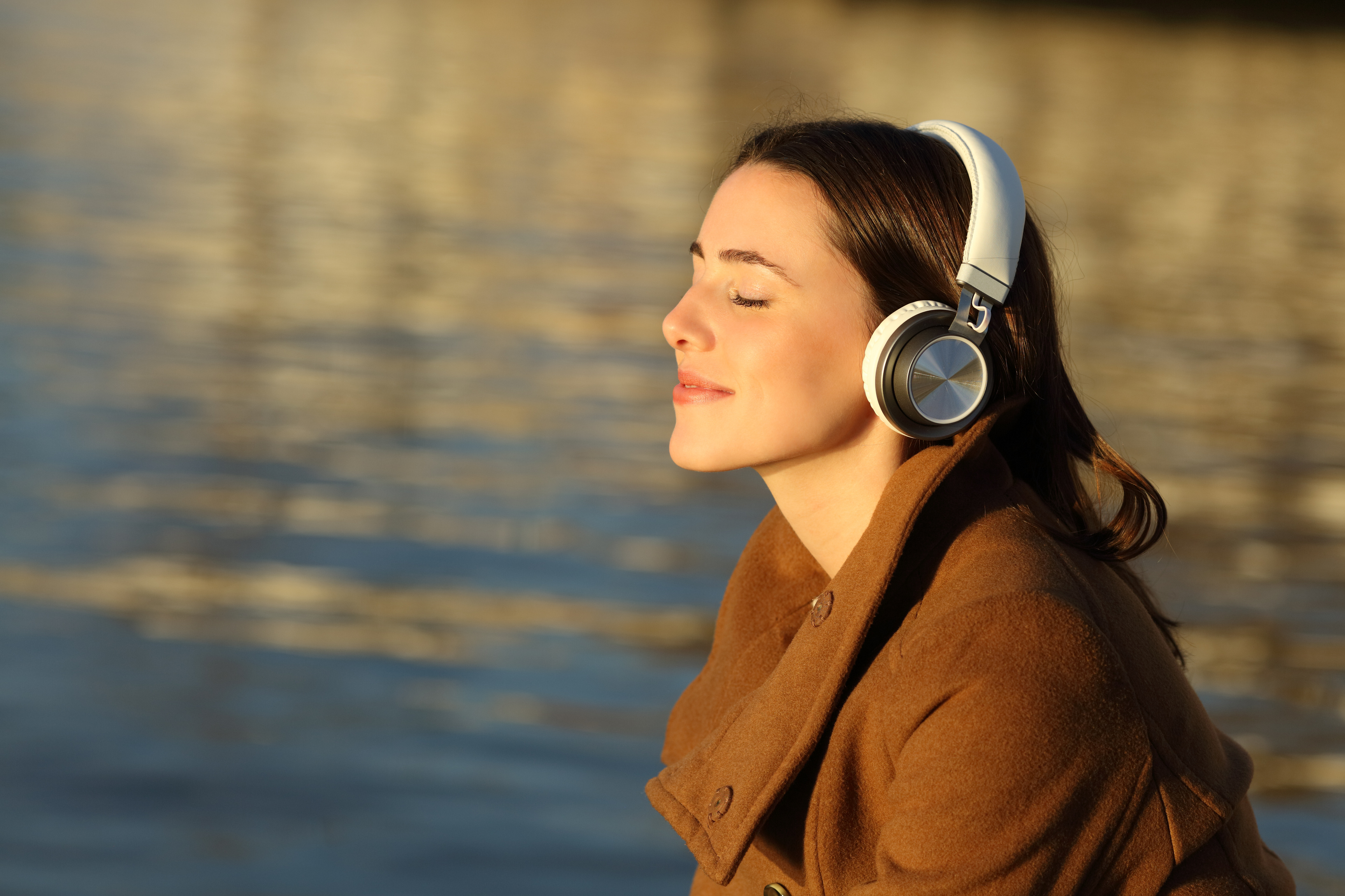 Woman meditating listening with headphones in winter